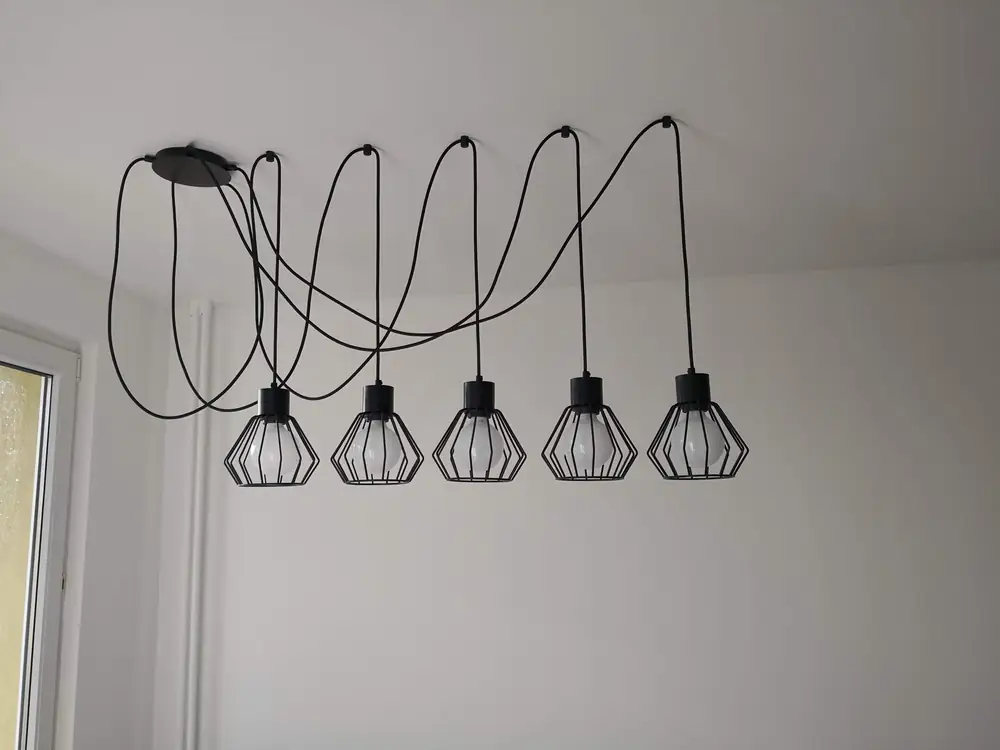 Industrialne lampy wiszące na kablach nad blatem